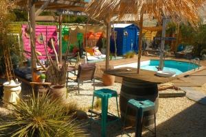 a swimming pool with a table and stools in a yard at La Norélie in Saint-Sulpice-de-Royan