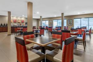 a restaurant with red chairs and tables and a bar at Comfort Suites San Antonio North - Stone Oak in San Antonio