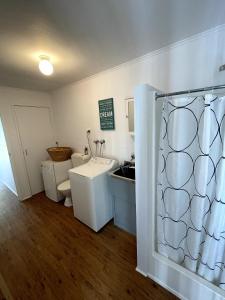 a bathroom with a toilet and a shower curtain at Saturn Parade Shack in Venus Bay +11 photos