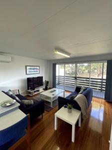 a living room with a couch and a table at Saturn Parade Shack in Venus Bay
