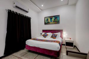 a bedroom with a large bed in a room at FabHotel Kences Inn in Chennai