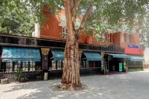 a tree sitting in front of a building at FabHotel Kences Inn in Chennai
