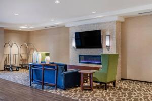 a hotel room with a lobby with a tv and chairs at Comfort Inn & Suites Clarkston Pine Knob Area in Clarkston