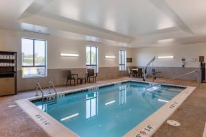 a swimming pool in a hotel with chairs and tables at Comfort Inn & Suites Clarkston Pine Knob Area in Clarkston
