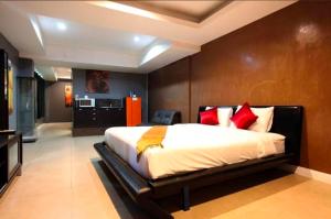 a bedroom with a large bed with red pillows at DelMar by Mery World Hospitality in Pattaya South