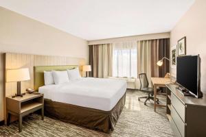 a hotel room with a large bed and a desk at Country Inn & Suites by Radisson, Flagstaff Downtown, AZ in Flagstaff +28 photos