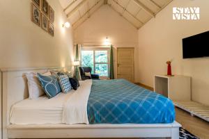 a bedroom with a king sized bed with a tv on the wall at StayVista at Jungle Jade with WiFi in Madikeri