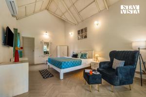 a bedroom with a bed and a chair at StayVista at Jungle Jade with WiFi in Madikeri
