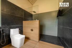 a bathroom with a toilet and a shower at StayVista at Jungle Jade with WiFi in Madikeri +13 photos