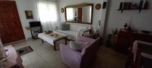 a living room with a couch and a mirror at Elizas house in Nea Makri