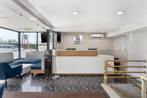 an office with a reception desk and blue chairs at Quality Inn JFK Airport Rockaway Blvd in Queens