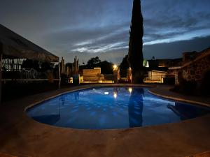 a large blue swimming pool in a yard at night at Casa Jardín Santiago in Texcoco de Mora +4 photos