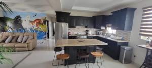 a kitchen with a couch and a table and chairs at Cabañas Privadas San Carlos Escape & Relax in Ensenada