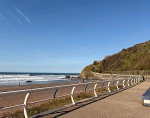 a beach with a fence next to the ocean at Apartamento Cueto II in Soto del Barco
