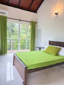 a bedroom with a bed with green sheets and a window at Hillcrest Bungalow in Matale