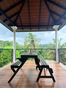 a table and benches on a porch with a view at Hillcrest Bungalow in Matale +14 photos