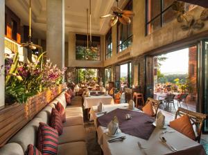 a restaurant with tables and chairs and flowers at Katiliya Park Villa in Mae Chan