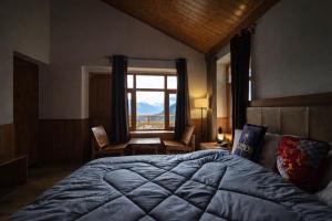 a bedroom with a large bed and a large window at Hotter Potter Stays Manali in Vashisht