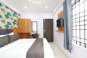 a bedroom with a bed and a tv on a wall at Golden Comforts Banglore in Bangalore