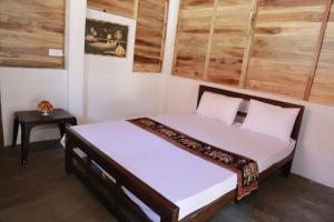a bedroom with a bed in a room with wooden walls at Ocean View Beach Resort - Kalpitiya in Kalpitiya