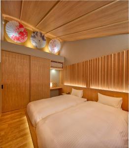 a bedroom with two beds and two plates on the wall at 鴨川せせらぎ庵 in Kyoto