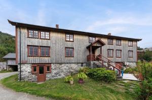 a large wooden house with a staircase in front of it at Staurset gård in Mittet
