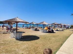 a group of people sitting on a beach with umbrellas at Mobile Home River in Privlaka