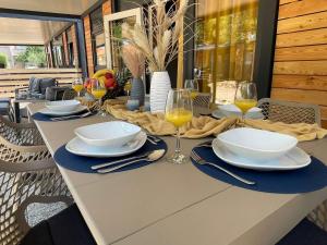a dining table with plates and glasses of wine at Mobile Home River in Privlaka