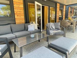 a patio with a couch and chairs and a table at Mobile Home River in Privlaka +7 photos