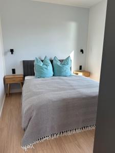 a bedroom with a large bed with blue pillows at Ferienhaus Sonnenperle am Partwitzer See in Klein Partwitz