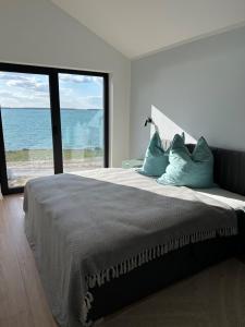 a bedroom with a bed with a view of the ocean at Ferienhaus Sonnenperle am Partwitzer See in Klein Partwitz
