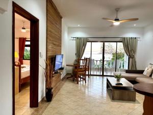 a living room with a couch and a dining room at Jardin Marron in Baie Sainte Anne