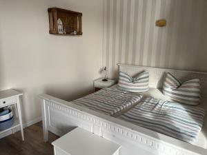 a white bed with two pillows on top of it at lüttjeseeblick13 in Nordstrand