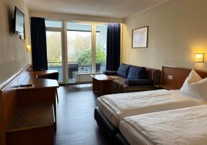 a hotel room with a bed and a couch at Fletcher Parkhotel Olsberg-Winterberg in Olsberg +34 photos