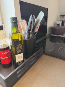 a bottle of wine next to a container of kitchen utensils at Kystvejen Øster Hurup in Hadsund +5 photos