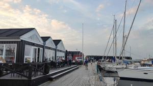 a dock with a restaurant and a marina with boats at Kystvejen Øster Hurup in Hadsund