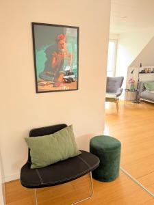 a living room with a chair and a painting on the wall at Kystvejen Øster Hurup in Hadsund