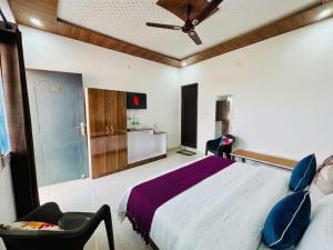 a bedroom with a large bed and a chair at Oliva by Quercus Oak Stays in Mussoorie +15 photos