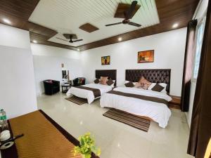 a bedroom with two beds and a ceiling at Oliva by Quercus Oak Stays in Mussoorie
