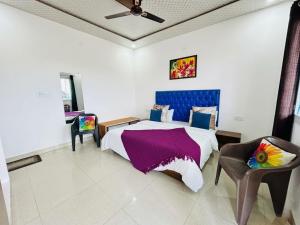 a bedroom with a large bed and a chair at Oliva by Quercus Oak Stays in Mussoorie