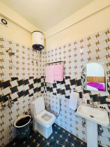 a bathroom with a toilet and a sink and a mirror at Oliva by Quercus Oak Stays in Mussoorie