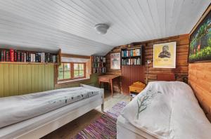 a bedroom with a bed in a room with bookshelves at Staurset gård in Mittet