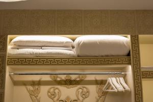 two pillows and towels on a shelf in a bathroom at CENTAURIA Greek Luxury Suite 5' Port Gate 7-8 & Cruises Gate 11-12 in Piraeus