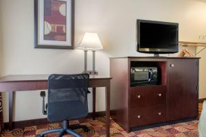 a hotel room with a desk with a television and a chair at Quality Inn Bloomington Near University in Bloomington