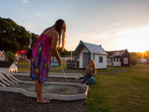 a woman is playing a game of golf at DCU-Camping Odense in Odense