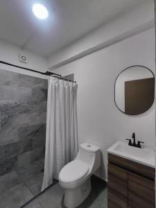 a bathroom with a toilet and a sink and a mirror at Freya studio III Romantic Zone in Puerto Vallarta