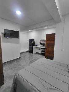 a white room with a bed and a kitchen at Freya studio III Romantic Zone in Puerto Vallarta