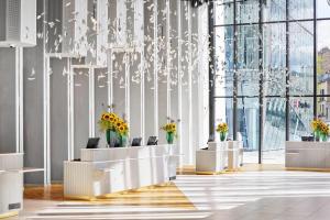 a lobby with flowers and a chandelier at H4 Wyndham Paris Pleyel in Saint-Denis