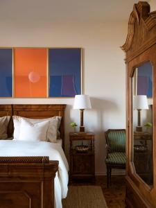 a bedroom with a large bed and a chair at La Giardina Guest House in Chieri