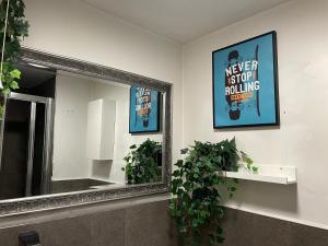 a mirror in a bathroom with two potted plants at Oakwood in Fleet